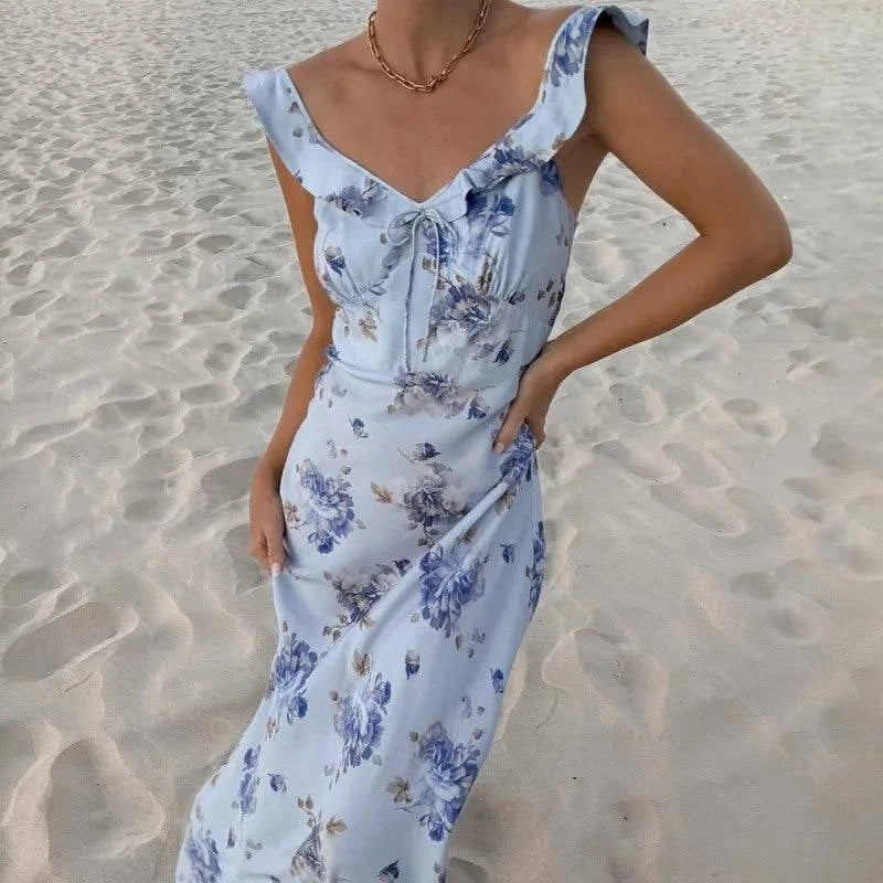 Woman wearing a yellow floral-print backless dress with flowing fabric and floral details